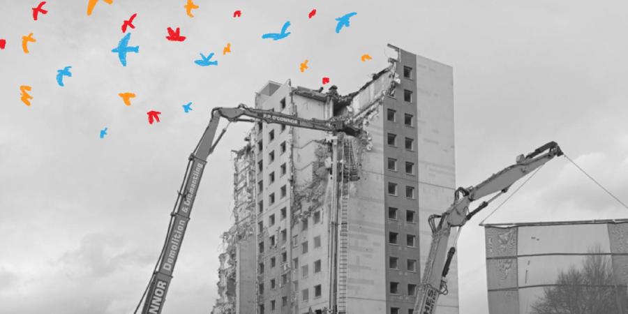 A black and white shot of a tower being demolished by a tall piece of heavy machinery with colourful birds flying from the wreckage